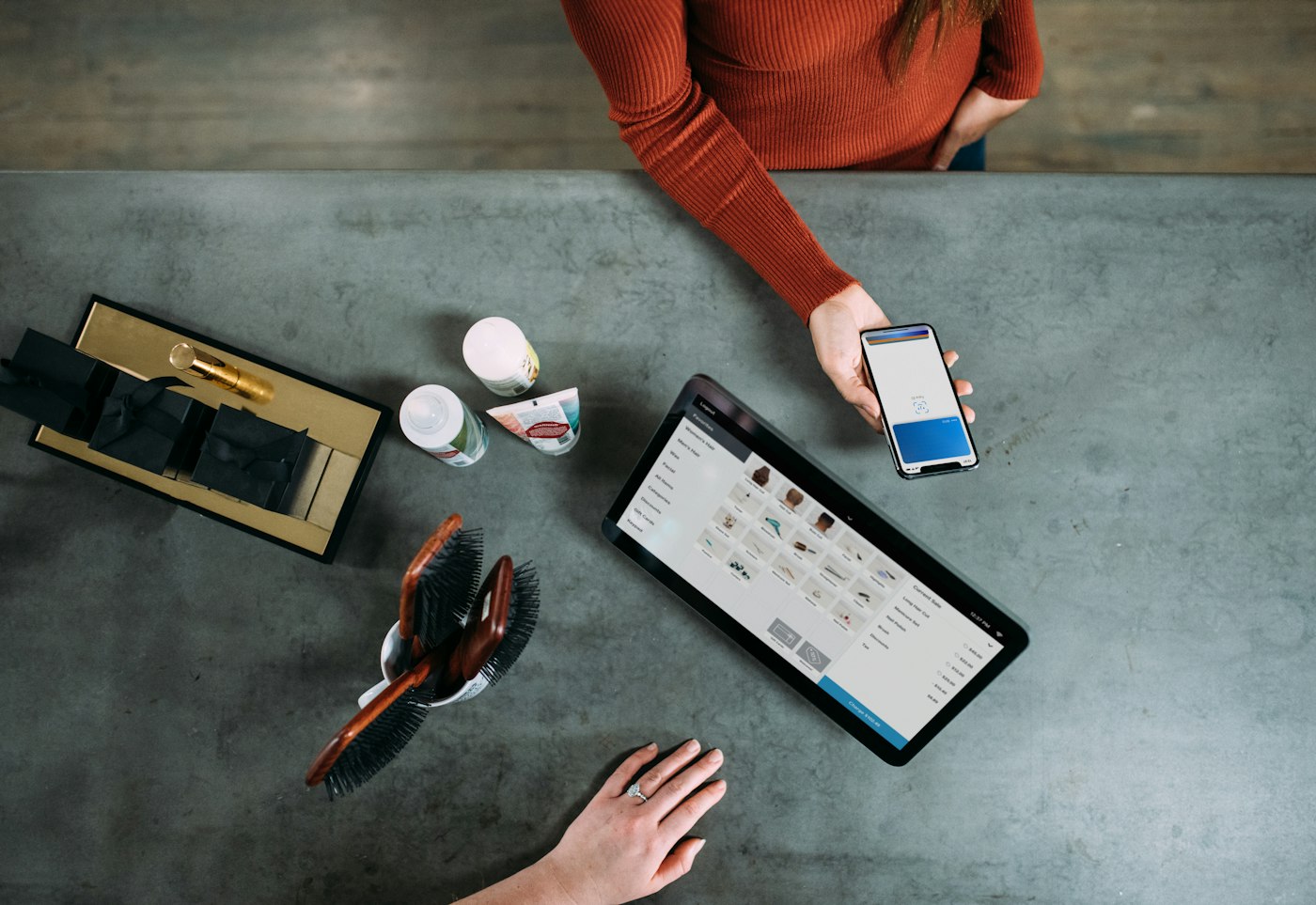 Overhead view of a customer paying by phone at a tablet checkout